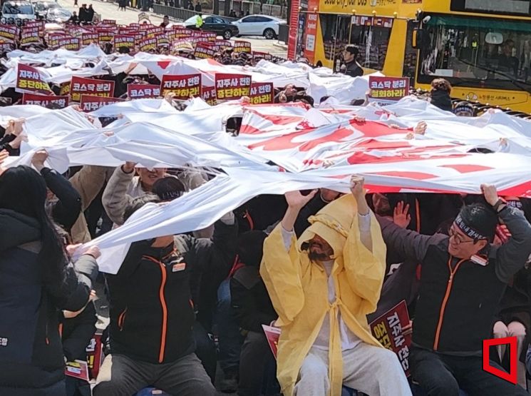 전국사무금융서비스노동조합 한국거래소 지부가 4일 오후 서울 종로구 청와대 사랑채 앞에서 ‘지주사 전환·코스닥 분리 반대’ 천 찢기 퍼포먼스를 하고 있다. 임춘한 기자