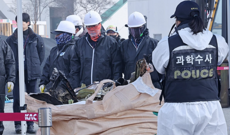 12일 무안국제공항에서 공항 관계자들이 12·29 제주항공 여객기 참사 사고기 잔해를 옮기고 있다. 연합뉴스