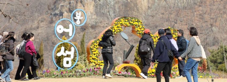 16일 광주와 전남 지역은 포근한 날씨를 보이겠으나 낮과 밤의 기온 차가 크게 벌어질 것으로 예보됐다. 사진은 지난 14일 전북 임실군 옥정호 붕어섬에서 관광객들이 수선화와 튤립 등이 피어있는 꽃길을 걷고 있는 모습. 전북 임실군 제공 연합뉴스