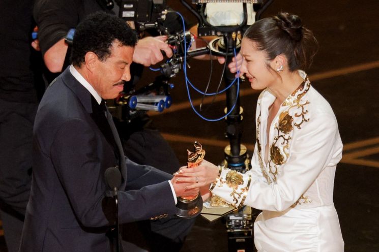 음악인 라이오넬 리치(왼쪽)가 제98회 아카데미 시상식에서 이재에게 주제가상 트로피를 건네주고 있다. 로이터연합뉴스