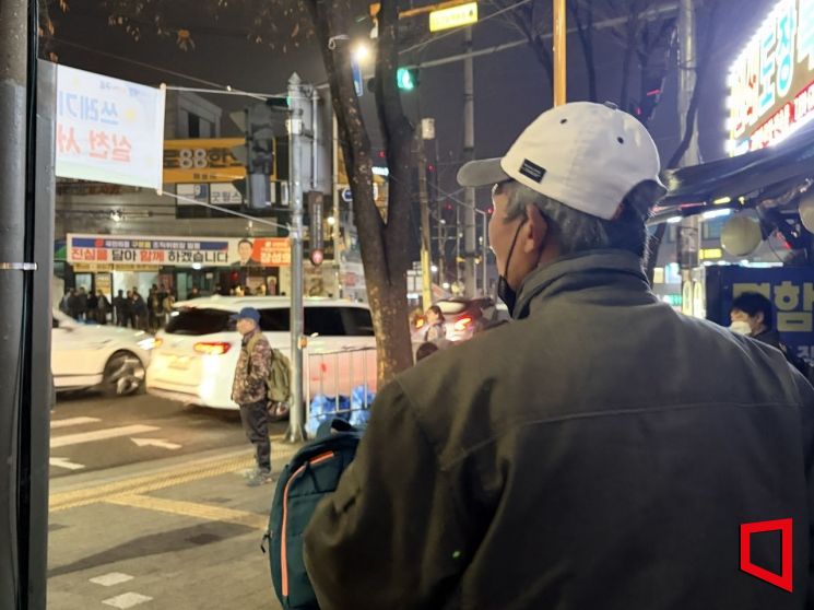 13일 오전 5시께 서울 구로구 인력사무소 앞 한국인 구역에 있는 한 노동자가 사람이 몰려있는 외국인 구역을 바라보고 있다. 이지예 기자.