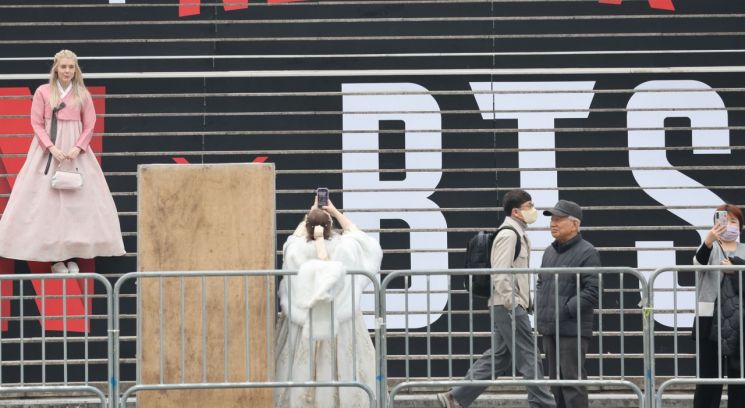 방탄소년단(BTS) 컴백 공연이 닷새 앞으로 다가온 지난 16일 세종문화회관 계단에서 외국인 관광객들이 BTS 홍보물을 기념촬영하고 있다. 연합뉴스