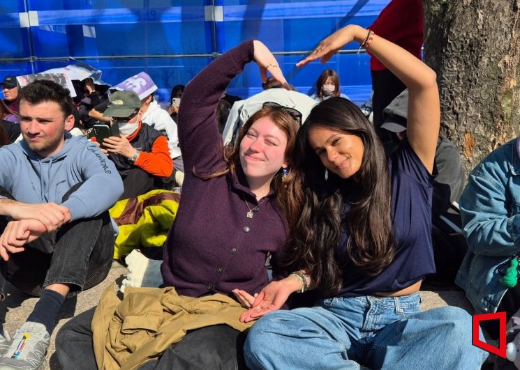 서울 광화문역 4번 출구 앞 공터에서 공연을 기다리고 있는 프랑스 출신 교환학생 우스안씨(왼쪽)와 메이윈씨가 하트를 만들어 보이고 있다. 오지은 기자