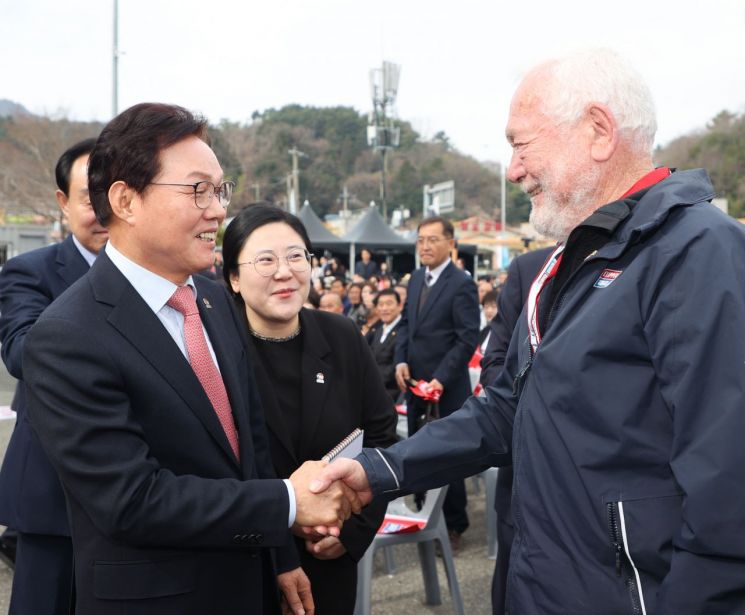 박완수 경남도지사(왼쪽)가  '2025-26 클리퍼 세계일주 요트대회' 8번째 기항지 통영에서 열린 요트 출항식에서 로빈 녹스 존스턴 경과 악수를 나누고 있다. 경남도 제공