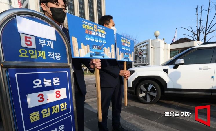 중동사태에 따른 에너지 절약을 위해 공공부문 '승용차 5부제(요일제)'가 본격 시행된 25일 서울 종로구 정부서울청사 출입문에서 청사관리소 관계자들이 승용차 5부제 캠페인을 하고 있다. 2026.3.25 조용준 기자