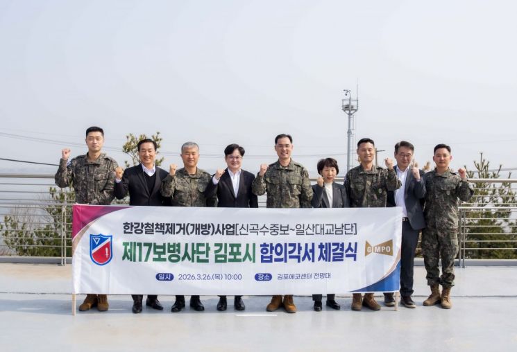 김병수 김포시장과 군 관계자들이 26일 육군 제2291부대와 신곡수중보부터 일산대교 남단까지 한강변 경계철책 철거 구간에 대한 수정 합의각서를 체결한 후 기념촬영을 하고 있다. 김포시 제공