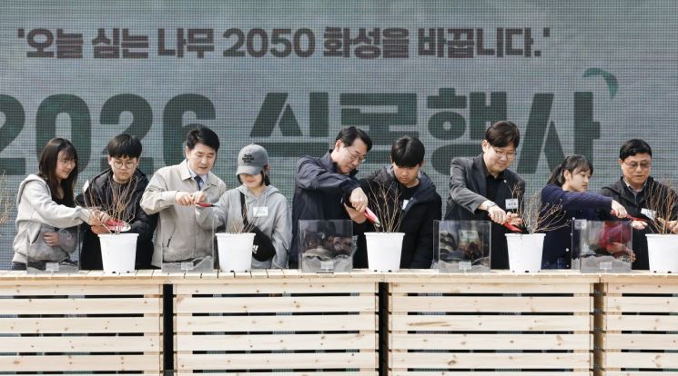 以 Jeong Myeonggeun 华城特例市长为首的与会者们正在利用生物炭种植纪念树。华城市提供