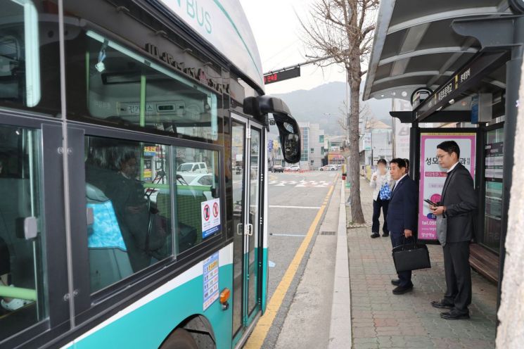 右起第二位的梁山市市长 Na Dongyeon 正在践行车辆限行五日制，乘坐公共交通工具。梁山市提供