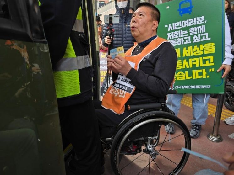 31일 오후 서울 서초구 서울고속버스터미널에서 권달주 전국장애인이동권연대 대표가 고속버스 승차권을 내보이며 탑승을 막는 직원에게 항의하고 있다. 연합뉴스