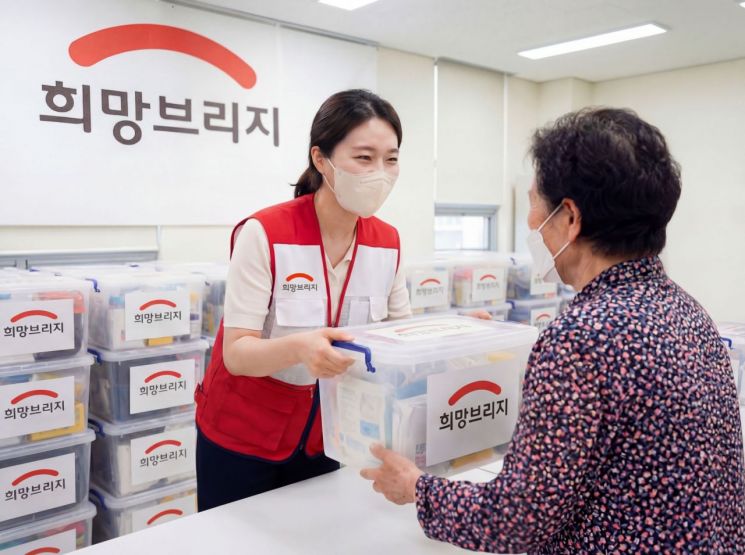희망브리지 전국재해구호협회 직원이 어르신에게 구호물품을 전달하고 있다. 희망브리지