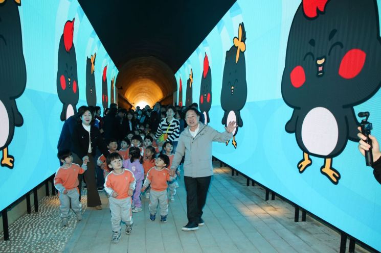Ju Gwangdeok南杨州市长31日在Wabu邑Dogok里一带举行利用废弃隧道打造的“光之隧道公园”竣工仪式后，正与儿童一起步行。南杨州市提供