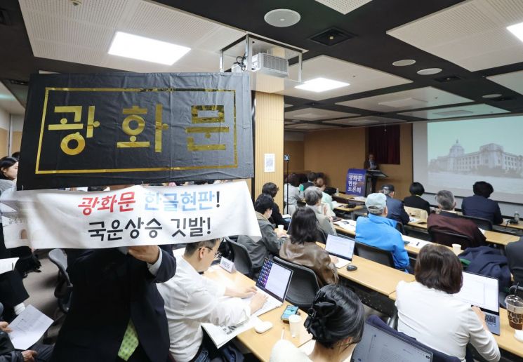 31일 서울 종로구 대한민국역사박물관에서 열린 '광화문 현판 토론회'에서 한 참석자가 한글로 쓴 광화문 문구를 들고 있다. 연합뉴스