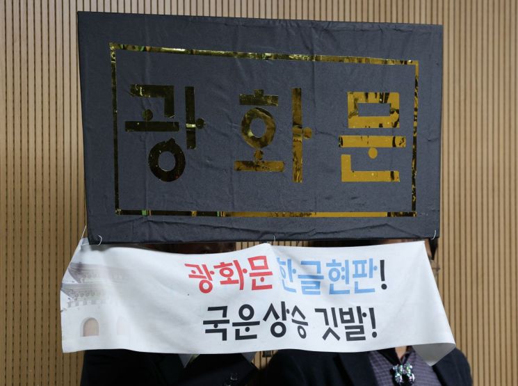 31일 서울 종로구 대한민국역사박물관에서 열린 '광화문 현판 토론회'에서 한 참석자가 한글로 쓴 광화문 문구를 들고 있다. 연합뉴스