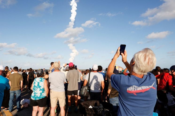 1일(현지시간) 미국 플로리다주 타이터스빌에서 사람들이 항공우주국(NASA) 케네디 우주센터의 아르테미스 2호 달 궤도 비행 임무인 차세대 달 탐사 로켓 '우주발사시스템(SLS)'과 '오리온' 유인 캡슐의 발사 당일 현장에 모여 있다. 플로리다(미국)=로이터연합뉴스