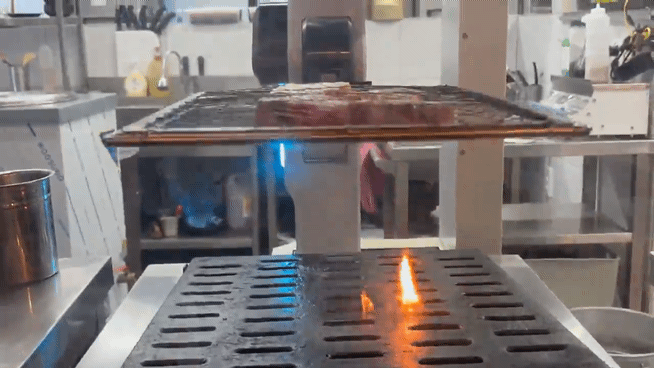 경기 수원시 팔달구의 한 고깃집에서 비욘드허니컴의 '그릴X'가 삼겹살을굽던 중 그릴을 들어올려 불길을 잡고 있다. 황서율 기자