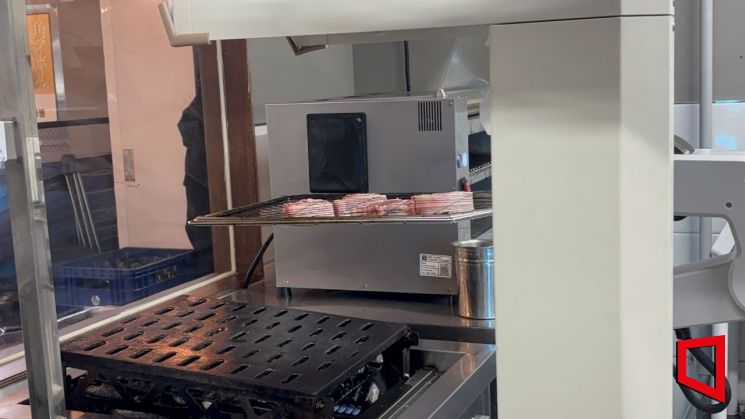 경기 수원시 팔달구의 한 고깃집에서 비욘드허니컴의 '그릴X'가 그릴에 올린 삼겹살을 불판 위로 이동시키고 있다. 황서율 기자