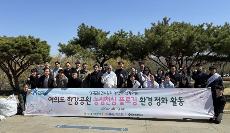 Employees of NH Nonghyup Bank and the Korea Institute of Financial Training are posing for a commemorative photo after participating in plogging at Yeouido Hangang Park in Seoul on the 7th. NH Nonghyup Bank