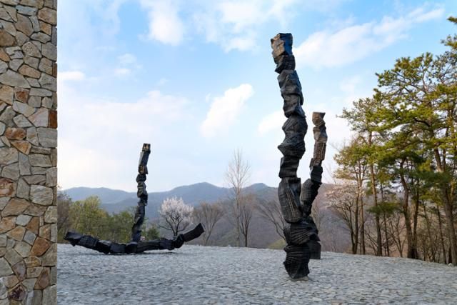 뮤지엄 산에서 열리는 이배의 개인전 중 '무의 공간'에 설치된 '붓질'. 이배 특유의 숯 질감을 흉내 낸 청동 구조물로, 뮤지엄 산 주변의 자연과 조화를 이룬다. 뮤지엄 산