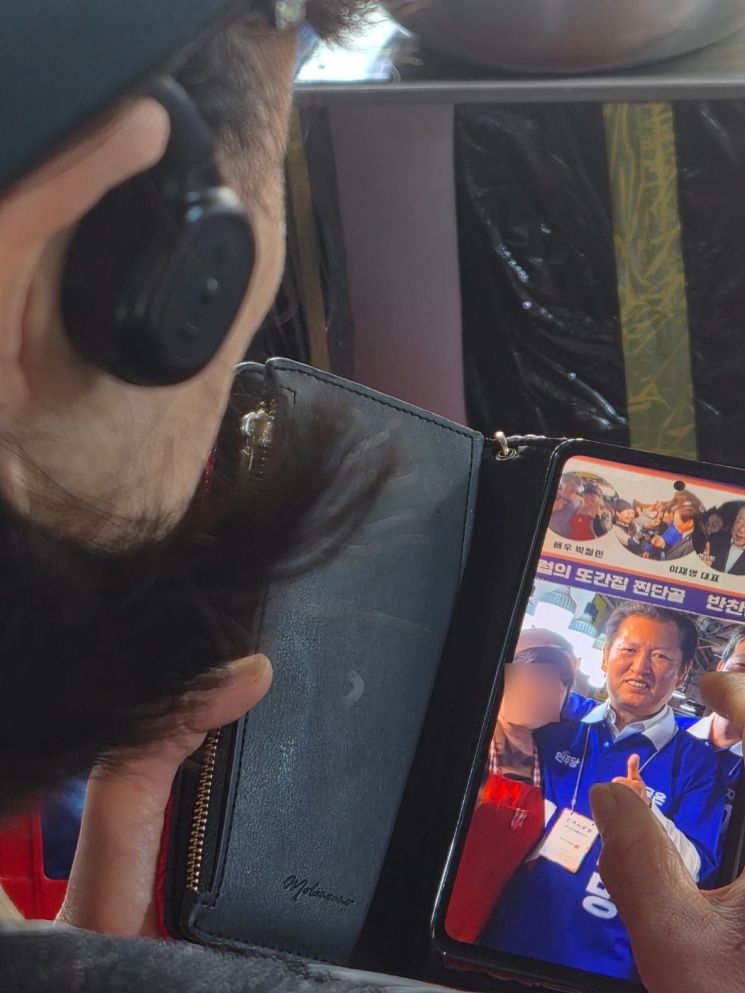 9일 광주 서구 양동시장에서 한 상인이 휴대전화에 저장해 둔 정청래 더불어민주당 대표와의 과거 촬영 사진을 보여주고 있다. 송보현 기자