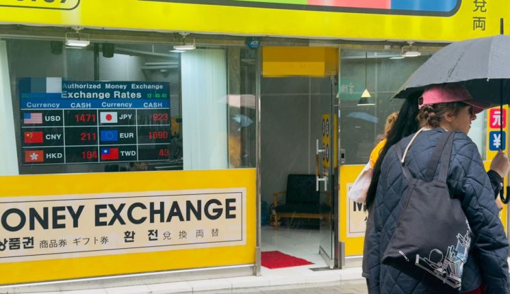 지난 8일 오후 서울 중구 한 환전소 간판에 1달러당 1471원이 표시된 가운데 외국인 관광객이 앞을 지나가고 있다. 최근 원·달러 환율이 1500원을 넘나드는 등 고환율 흐름이 이어지면서 외환시장 변동성이 확대되고 있다. 박호수 기자