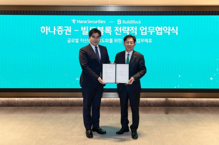 Sungmook Kang, CEO of Hana Securities (right), and Jiweon Jeong, CEO of Buildblock, are posing for a commemorative photo at the strategic business agreement ceremony for advancing global asset management services held at Hana Securities THE Centerfield W. Hana Securities