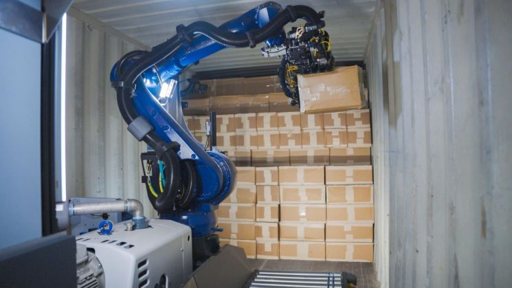 한국 AI로봇 스타트업 콘토로가 개발한 AI 기반 로봇 팔이 트럭에서 상자를 내리고 있다. 쿠팡Inc 홈페이지