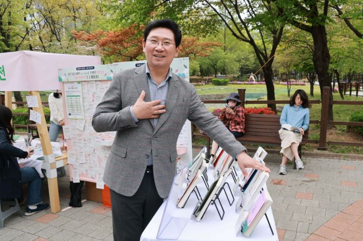 이상일 용인특례시장이 17일 수지구 신정공원 독서광장에서 열린 ‘제2회 공원 리딩 파티’ 현장을 찾아 체험 부스를 둘러보고 있다. 용인시 제공