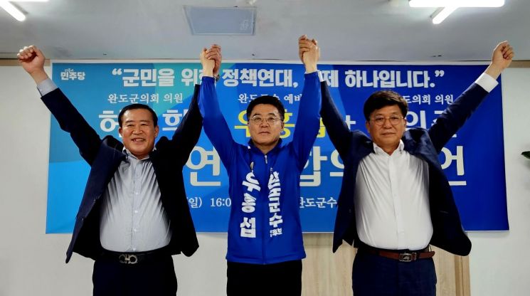 더불어민주당 우홍섭 완도군수 후보(가운데)가 신의준 전남도의원(오른쪽), 허궁희 완도군의원(왼쪽)과 정책 연대에 합의한 뒤, 손을 맞잡아 들어 올리며 지방선거 필승을 다짐하고 있다. 이준경 기자
