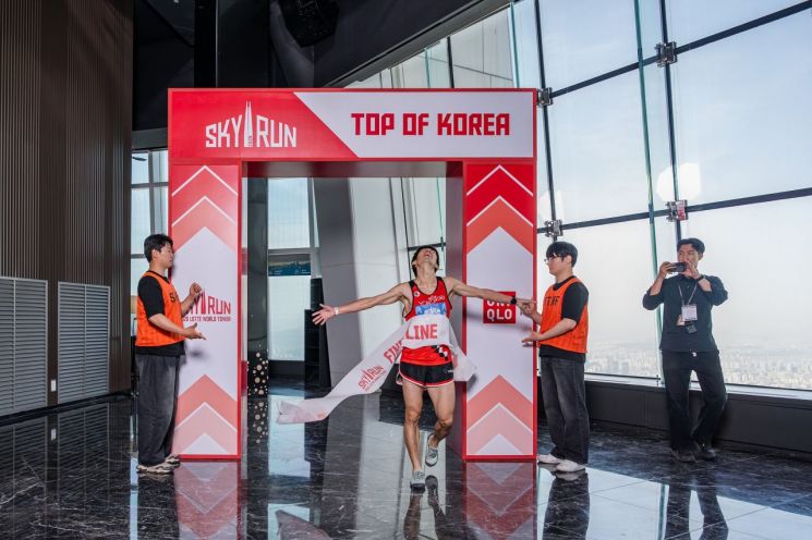 2026 롯데월드타워 스카이런에서 엘리트 부문 남자부 1위를 차지한 료지 와타나베(일본·오른쪽에서 세 번째)씨가 결승선을 통과하고 있다. 롯데물산 제공