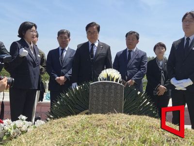 우원식 국회의장이 21일 광주 북구 운정동 국립 5·18민주묘지에서 참배하며 윤상원 열사의 묘비를닦고 있다. 민현기 기자