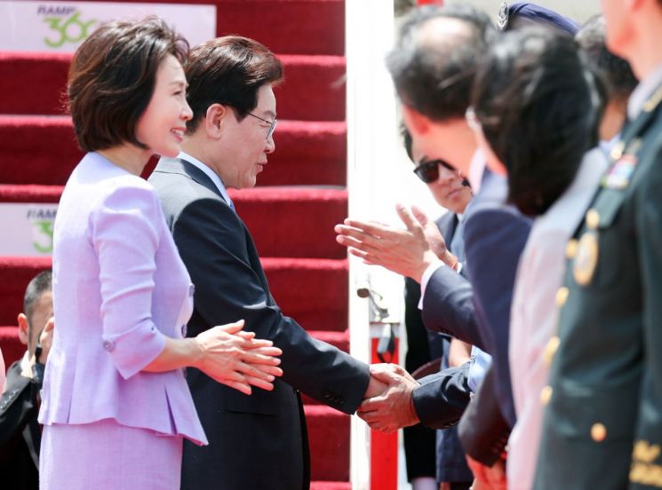 인도 국빈방문을 마친 이재명 대통령과 김혜경 여사가 21일(현지시간) 다음 국빈 방문지인 베트남으로 가기 위해 뉴델리 팔람 공군기지에서 공군 1호기에 탑승 전 환송객과 인사하고 있다. 연합뉴스