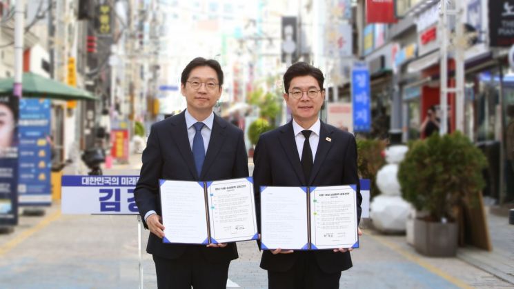 더불어민주당 김경수 경남도지사 후보(왼쪽)와 정원오 서울시장 후보가 경남 창원시 마산 창동문화예술촌에서 서명한 '경남-서울 상생협력 공동선언 협약서'를 들어 보이고 있다. [사진=이세령 기자]