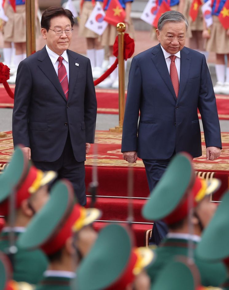 이재명 대통령과 또 럼 베트남 공산당 서기장 겸 국가주석이 22일(현지시간) 하노이 주석궁에서 열린 공식환영식에서 의장대 사열을 하고 있다. 연합뉴스