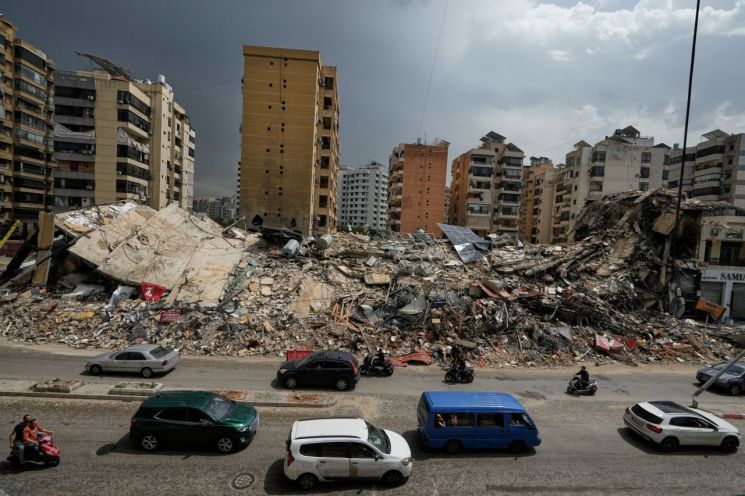 On April 17, 2026, residents pass by the debris of buildings destroyed following the ceasefire between Israel and Hezbollah in Dahieh, a southern suburb of Beirut, Lebanon (left). On April 20, 2026, a woman stands next to the debris of destroyed buildings after the ceasefire between Hezbollah and Israel in Dahieh, a southern suburb of Beirut, Lebanon. Photo by AP Yonhap News