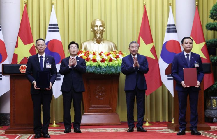 황기연 한국수출입은행 은행장과 레 응옥 썬 베트남 국가산업에너지공사(PVN) 회장이 22일(현지시간) 하노이 주석궁에서 이재명 대통령과 또 럼 공산당 서기장 겸 국가주석이 임석한 가운데 원전 프로젝트 금융 협력 가능성 검토 양해각서(MOU) 교환 후 기념촬영을 하고 있다. 연합뉴스