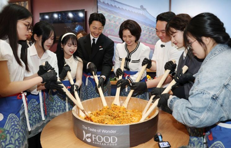 이재명 대통령과 베트남을 국빈 방문 중인 김혜경 여사가 23일(현지시간) 하노이 롯데몰에서 열린 K문화관광대전에서 비빔밥을 만들고 있다. 왼쪽은 배우 정일우. 연합뉴스