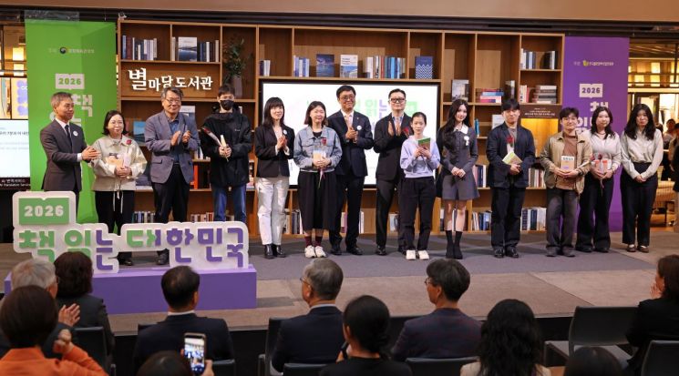 최휘영 문화체육관광부 장관이 23일 서울 강남구 코엑스 별마당도서관에서 열린 대국민 독서 캠페인 ‘2026 책 읽는 대한민국’ 선포식에 참석해 행사에 참석한 국민들에게 책을 선물하고 기념촬영을 하고 있다.  문화체육관광부