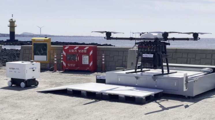 드론이 제주 비양도의 도킹스테이션에 배송한 물품을 실은 자율주행 로봇(왼쪽)이 배송지로 이동하고 있다. 우주청 제공
