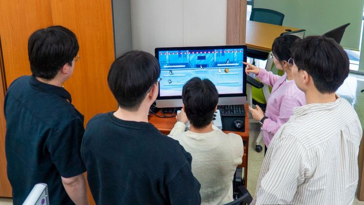 경남 김해문화관광재단 정책홍보팀 직원들이 직접 만든 레트로 게임 '토더기 어드벤처'를 시험하고 있다. [이미지제공=김해시]