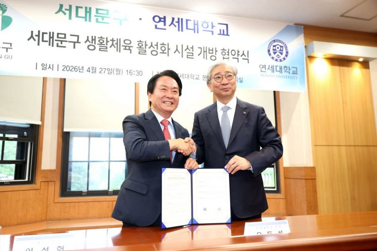 이성헌 서대문구청장(왼쪽)과 윤동섭 연세대학교 총장이 ‘생활체육 활성화를 위한 학교 체육시설 개방 업무 협약서’에 서명한 뒤 악수를 하고 있다. 서대문구 제공.