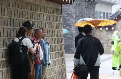 내일(30일) 광주와 전남 지역은 일교차가 크고 일부 지역에 비 소식이 예보됐다. 사진은 지난 20일 서울 종로구 경복궁 인근에서 한 시민이 우산을 들고 있는 모습. 연합뉴스