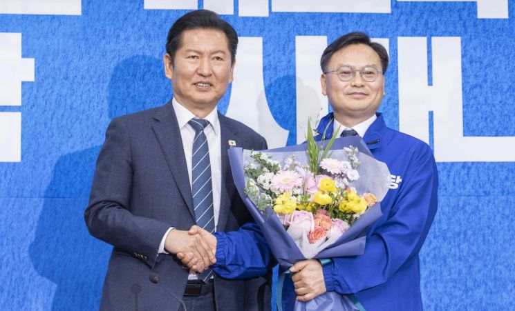 (서울=연합뉴스) 황광모 기자 = 6·3 재보선에서 제주 서귀포시에 출마할 것으로 예상되는 김성범 전 해양수산부 차관이 30일 국회에서 열린 더불어민주당 인재 영입식에서 정청래 대표에게 민주당의 상징 '파란 점퍼'를 받은 뒤 악수하고 있다. 2026.4.30    hkmpooh@yna.co.kr(끝)