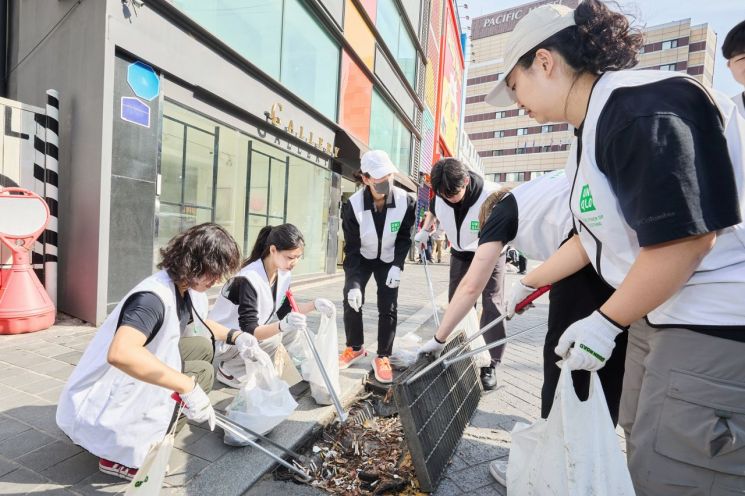 지난 29일 명동 일대에서 진행된 환경 정화 활동에서 유니클로 명동점 직원, 환경재단 관계자, 시민 자원봉사자가 명동 일대 상가와 관광객 밀집 지역 곳곳을 돌며 빗물받이 안에 쌓인 담배꽁초를 수거하고 있다. 유니클로는 ‘글로벌 플래그십 스토어 명동’의 오픈을 앞두고 환경재단과 함께 명동 일대에서 플로깅 활동을 마련했다.
