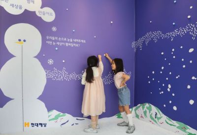 현대해상이 5월 가정의 달을 맞아 지난해에 이어 두번째로 개최한 '어린이눈높이전시회'에 방문한 어린이가 전시회장 벽면에 눈송이를 붙이고 있다. 현대해상