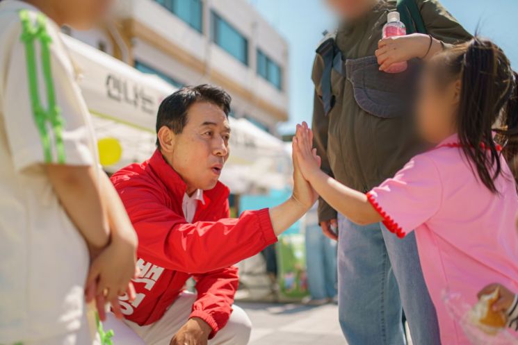 백영현 후보가 지난 5일 포천시청 일원과 소흘읍 생활 밀착형 복합 공간인 '두런두런'에서 열린 어린이날 기념 행사장을 찾아한 소녀와 하이파이브를 하고 있다. 백영현 후보 제공