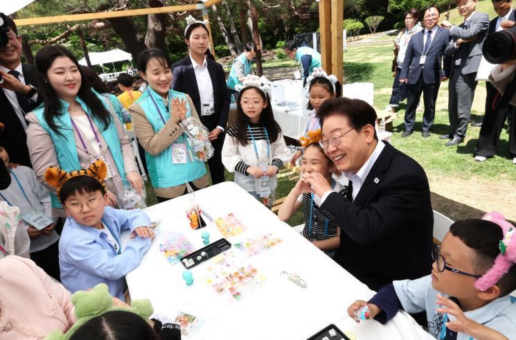 이재명 대통령이 5일 청와대 녹지원에서 열린 어린이날 초청행사에서 참석 어린이와 키캡 만들기 체험 후 기념촬영을 하고 있다. 연합뉴스