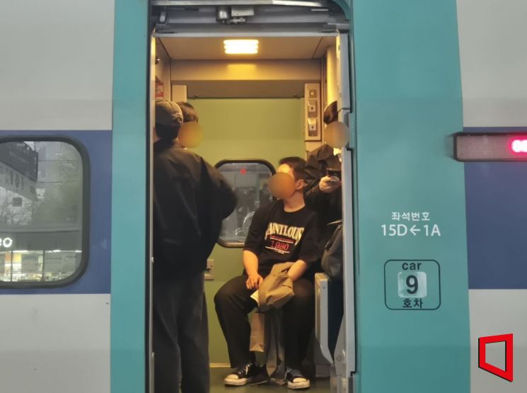 Passengers are packed into the standing car of the KTX train heading from Seoul to Busan. Although it is a weekday, the seats are fully occupied, and more than four people are gathered in the space between the compartments. Photo by Ji-eun Oh
