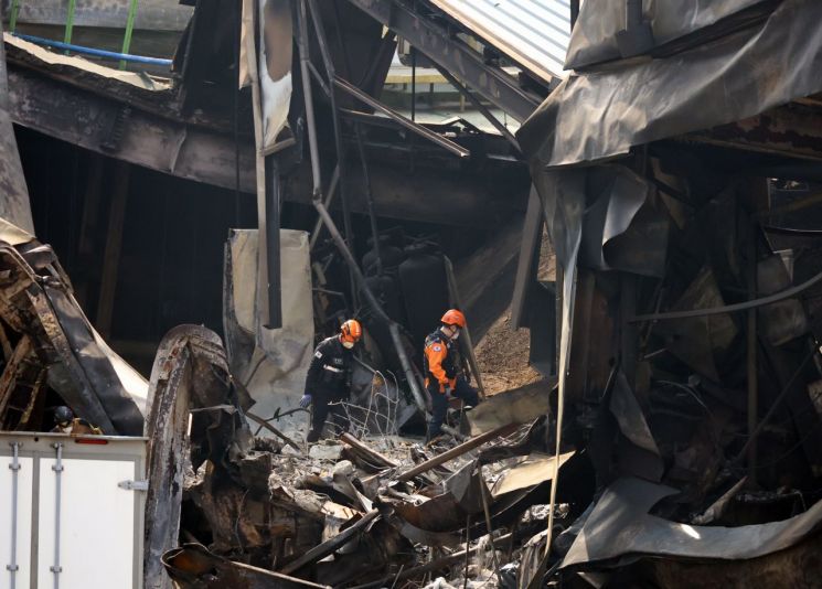 3月24日，在大田大德区一家名为安全工业株式会社的汽车零部件制造企业火灾现场，消防当局相关人员在事发后第二天进入被烧毁建筑内部进行勘验。联合新闻供图