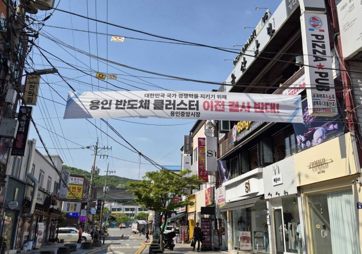 13일 용인중앙시장에 용인 반도체 클러스터 이전 요구에 반대하는 내용의 현수막이 걸려 있다. 김평화 기자