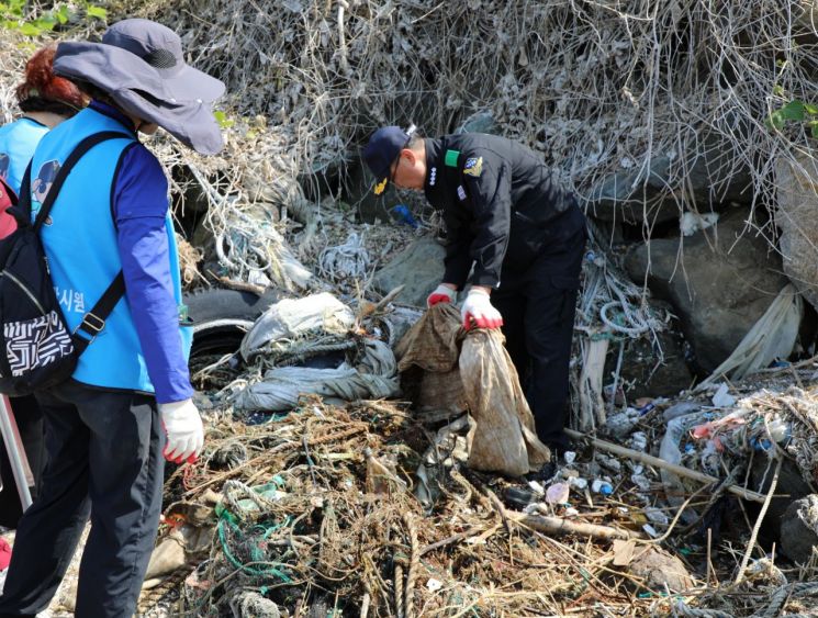 옥창묵 경남 창원해경서장이 창원시 마산합포구 브라운핸즈 앞 조간대 일대 해안에 밀려온 폐그물 등 해양쓰레기를 수거하고 있다. [사진제공=창원해양경찰서]